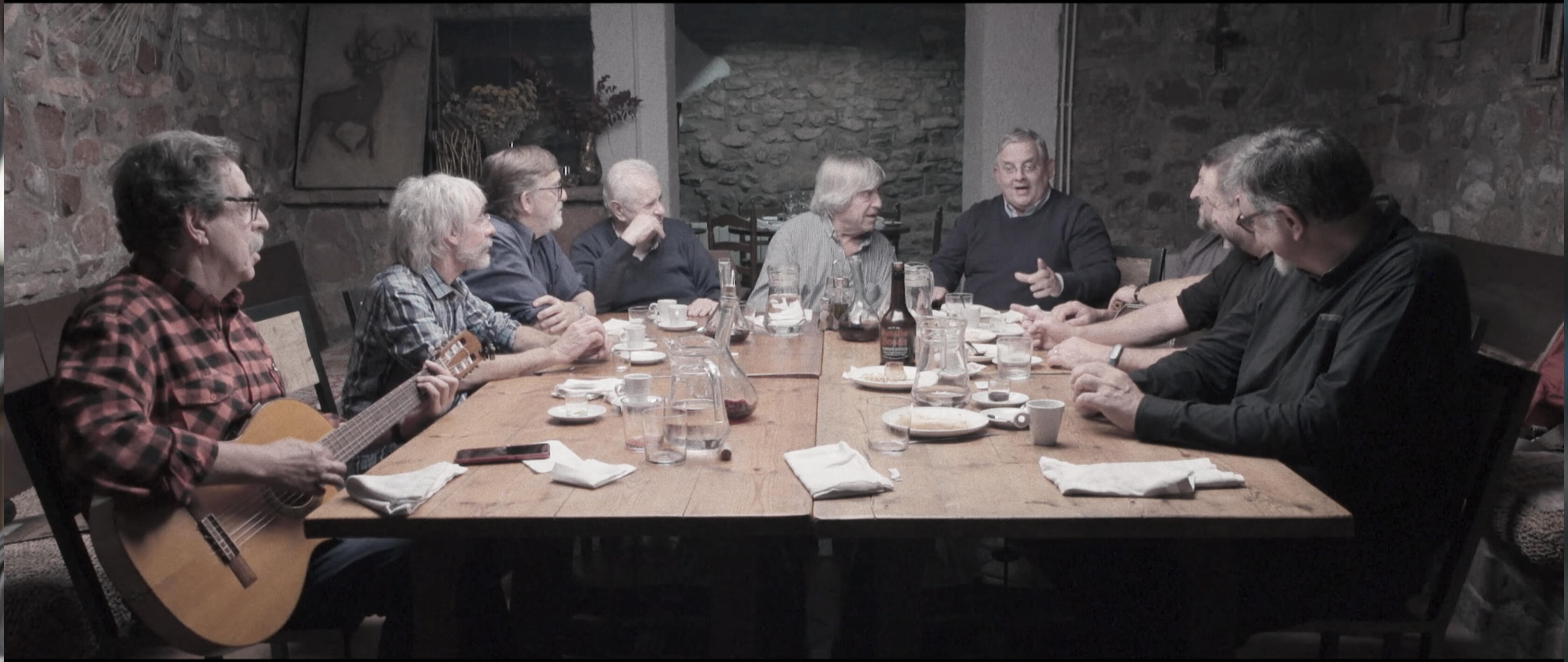 Imatge del documental Cantant està tot perdonat, sobre el patrimoni de la cançó popular catalana, amb músics reunits al voltant d’una taula.